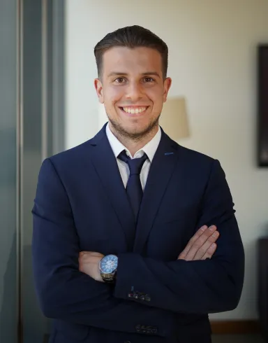 Man wearing suit and tie with arms crossed in front of his chest